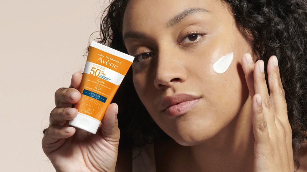 Žena nanosi Avene kremu s faktorom 50 za lice za zaštitu od sunčevih zraka.