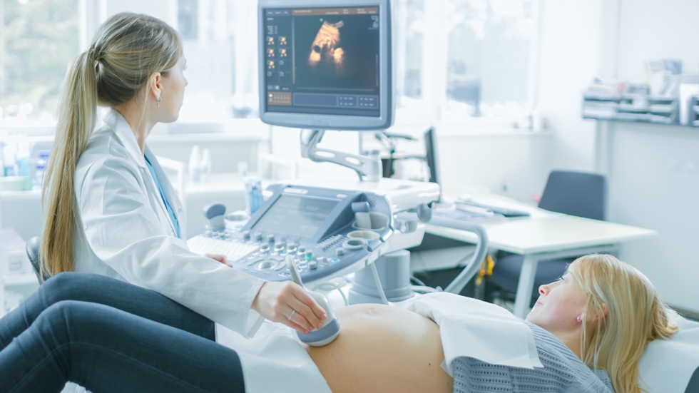 Žena leži na stolu, doktorica radi ultrazvučni pregled trudnice