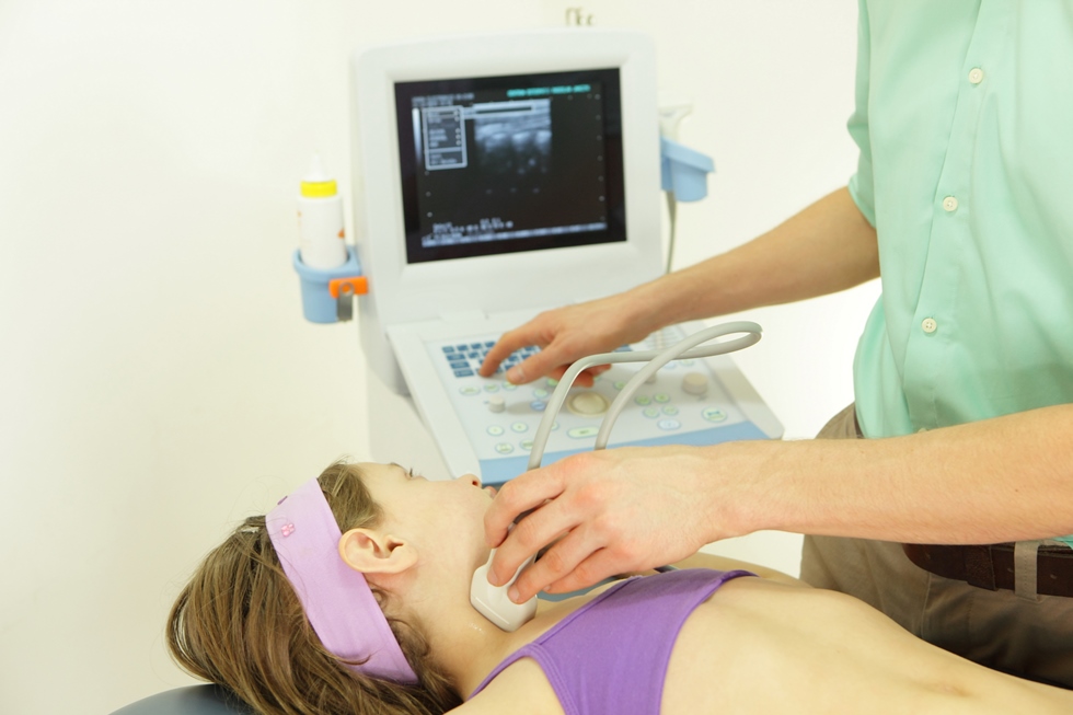 Doktor radi ultrazvuk limfnih čvorova dok dijete leži na stolu za pregled